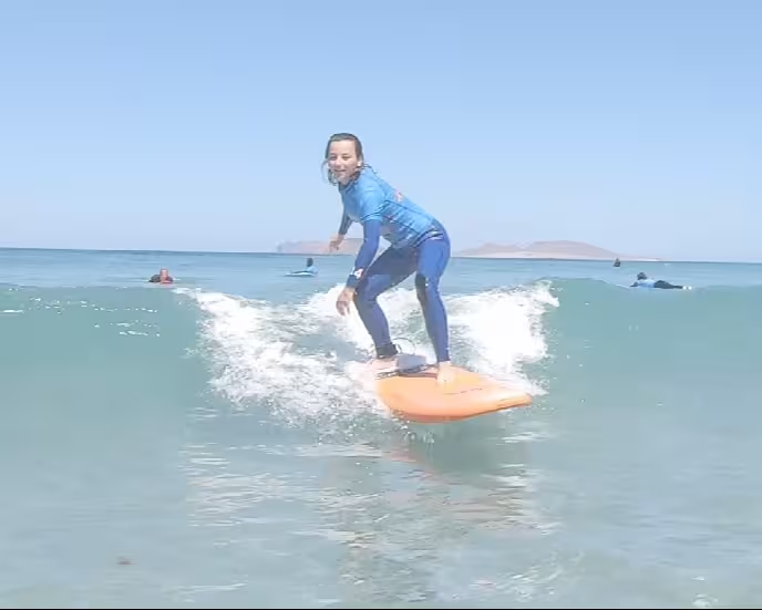Un surfista de nivel intermedio a avanzado surfea una ola verde de tamaño moderado.
